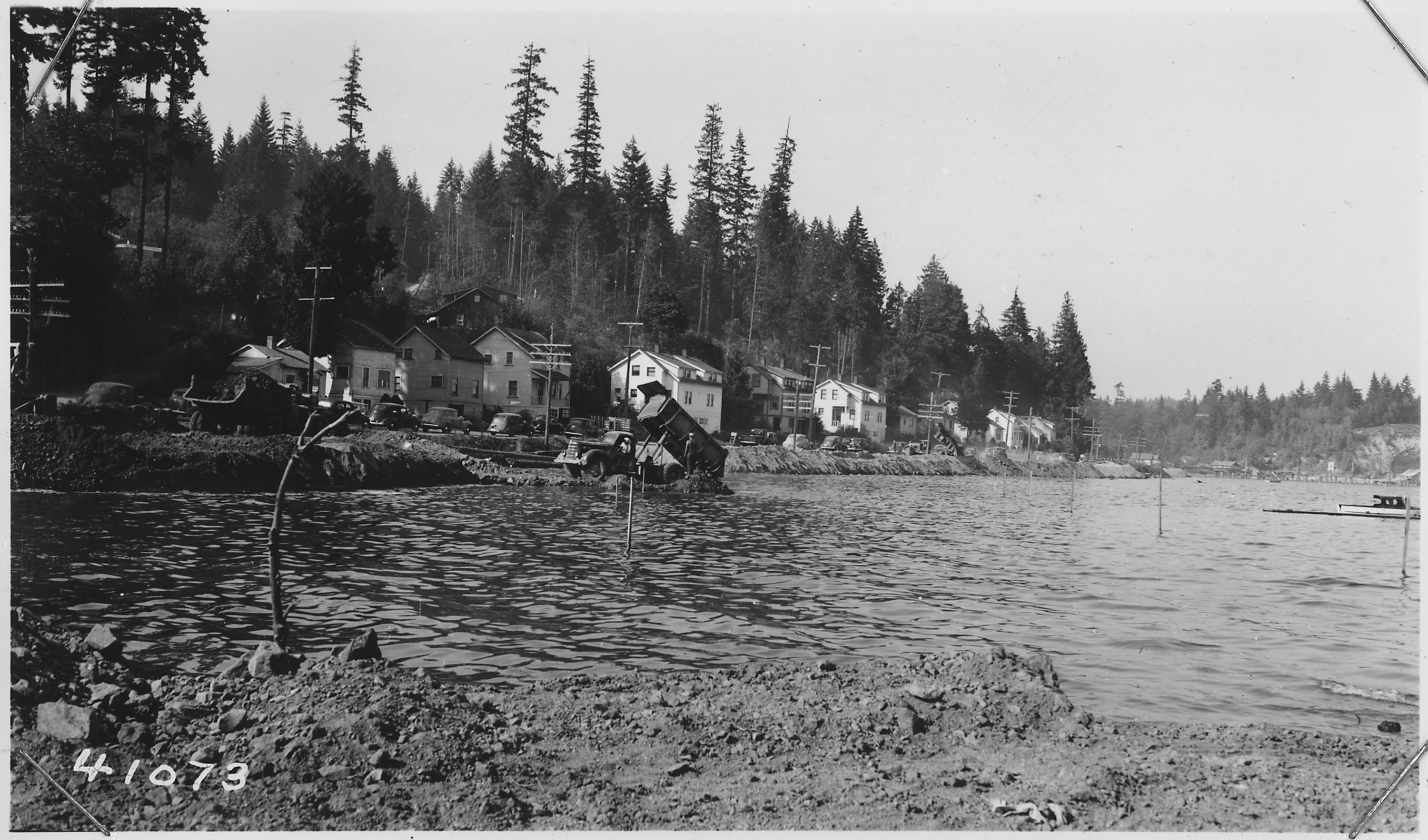 Rock_fill_being_made_at_Sta._78_during_high_tide_period._Stakes_at_right_are_at_toe_of_slope._Center_line_stakes_in..._-_NARA_-_298220.tif