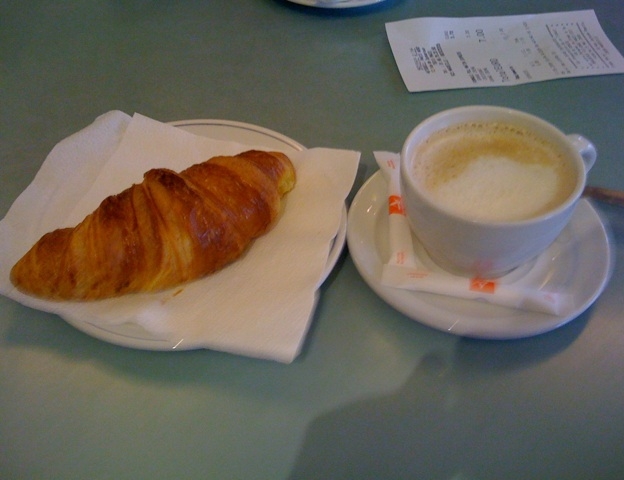 A meal with milk and a croissant.