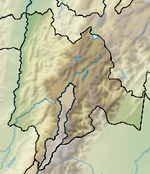 Mapa konturowa Cundinamarca, w centrum znajduje się owalna plamka nieco zaostrzona i wystająca na lewo w swoim dolnym rogu z opisem „Jezioro Guatavita”