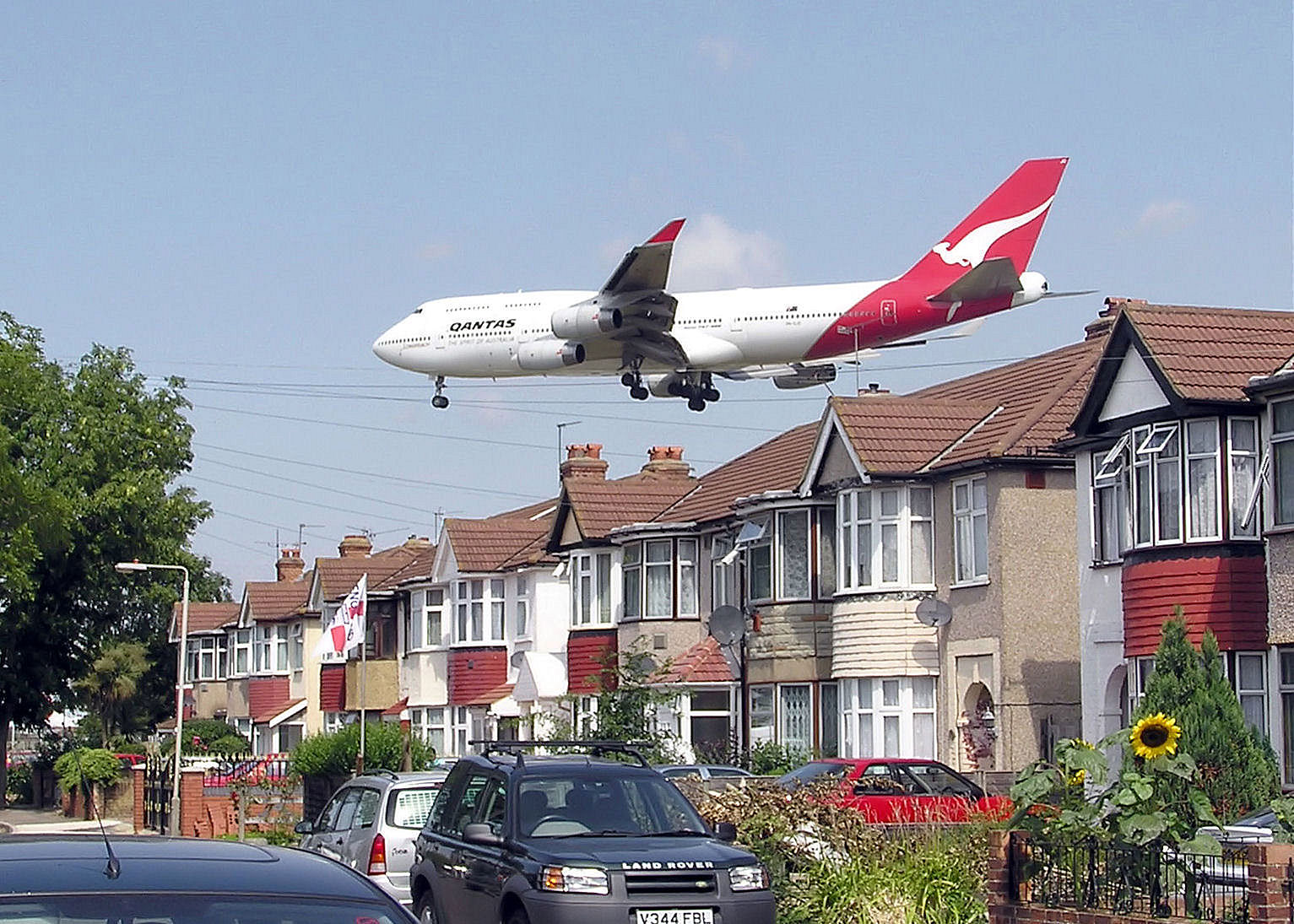 A Qantas Airways Boeing 747-400 passes close to houses shortly before landing at London Heathrow Airport.