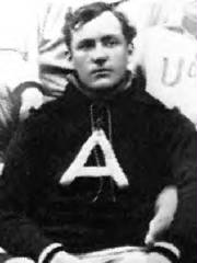 Black and white portrait of a man in a shirt with a letter A on it.