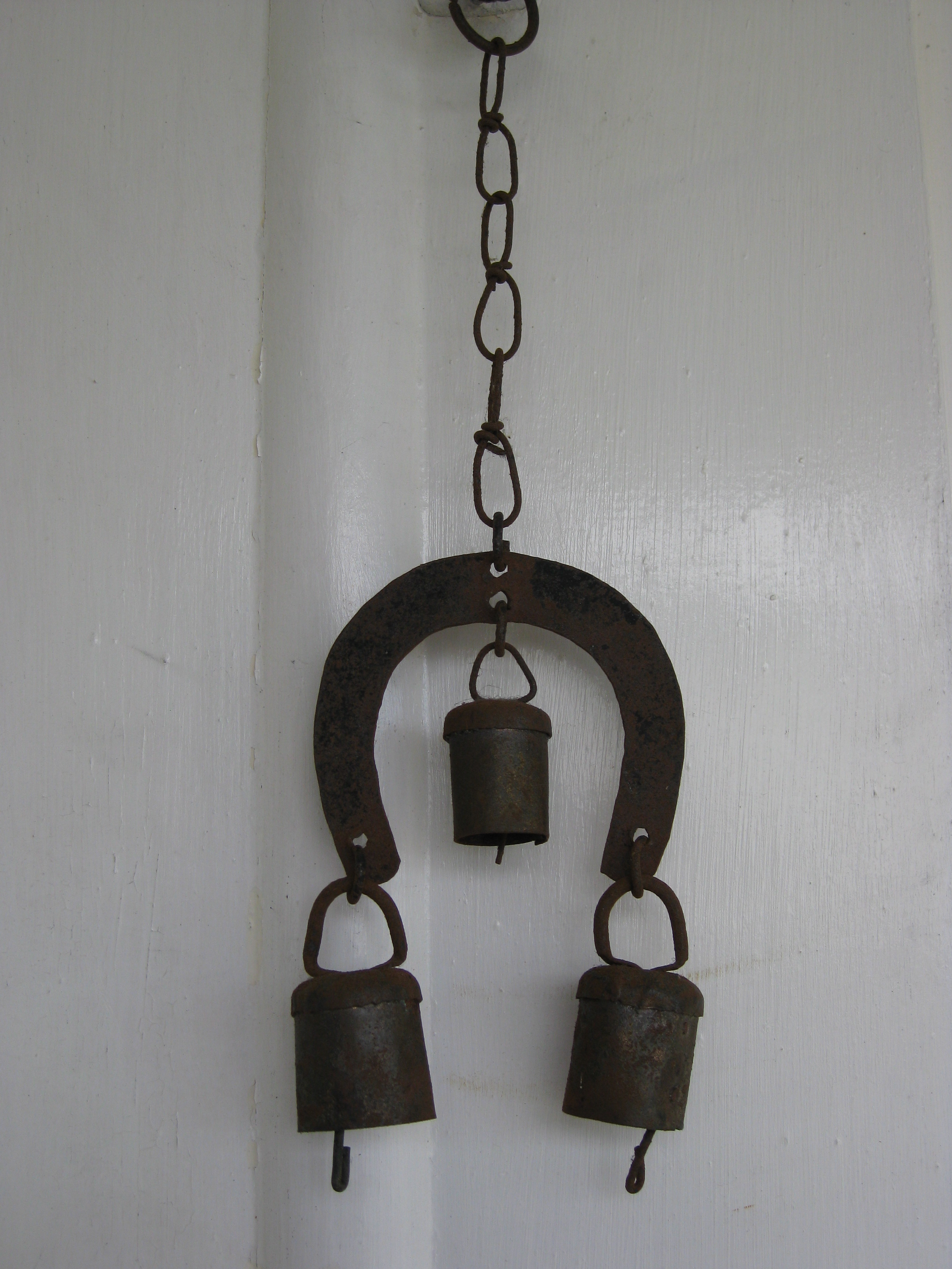 English: An old iron wind chime in the shape o...