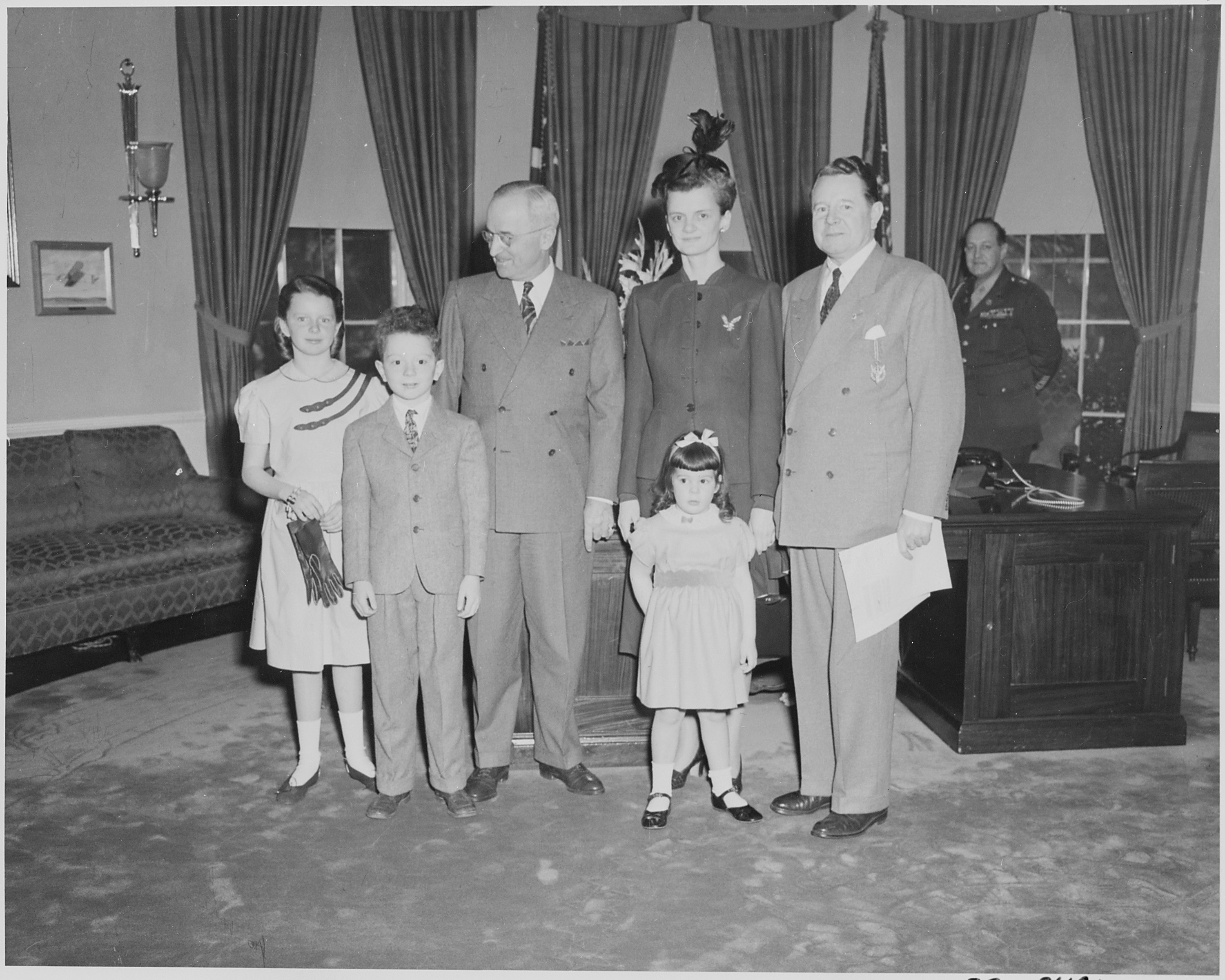 President Truman poses with Secretary of the Navy John L. Sullivan and his family in the oval office. Mr. Sullivan... - NARA - 199636.jpg