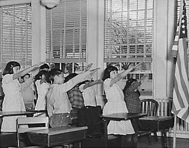Students in an unnamed school in 1941, offering the Bellamy Salute for the Pledge of Allegiance.