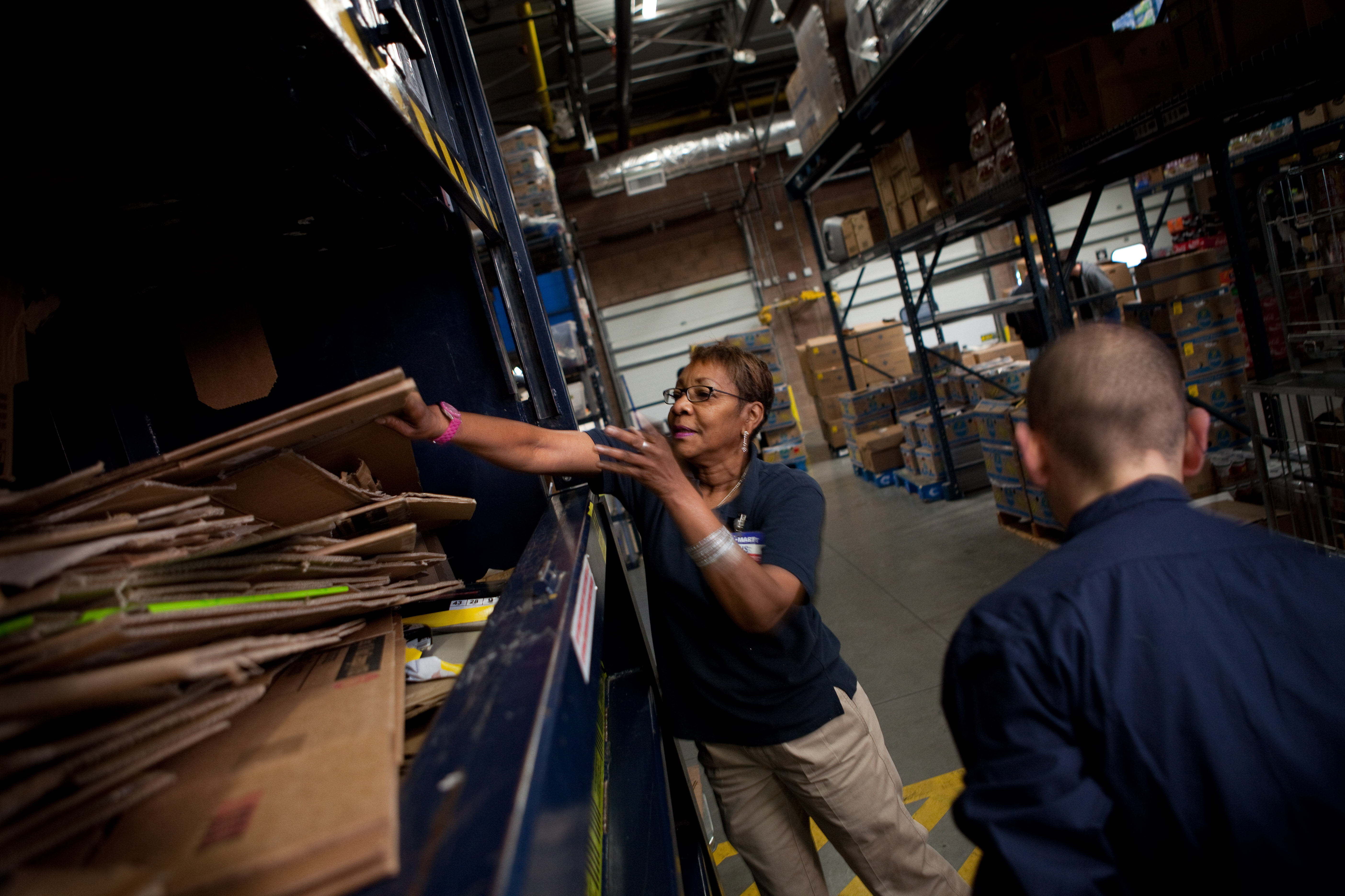 Description Walmart employees adding boxes to baler.jpg