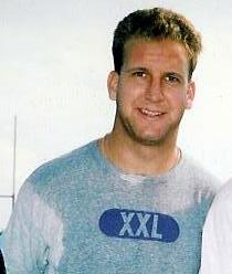 Изображение головы и плеч Джино Торретта, 23-летнего белого мужчины, в залитой потом вересковой спортивной футболке.