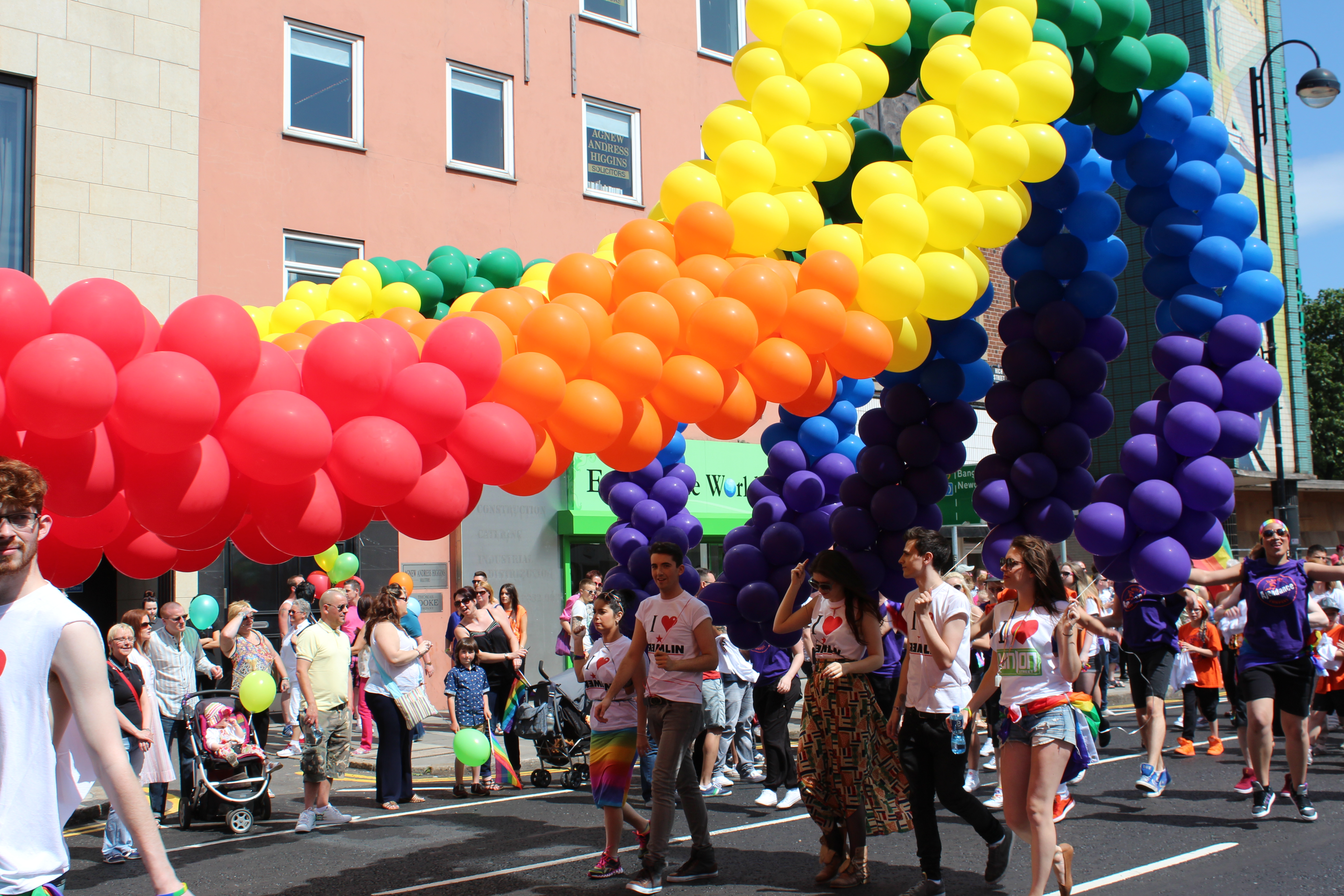 People march under a rainbow of balloons at the Belfast Pride parade.