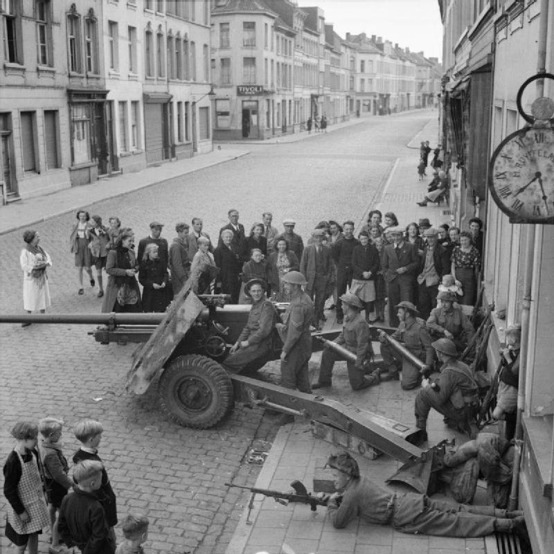 British soldiers manning a 76.2 mm Ordnance QF 17-pounder anti-tank gun during World War II. Third soldier from the left is holding an APDS round.