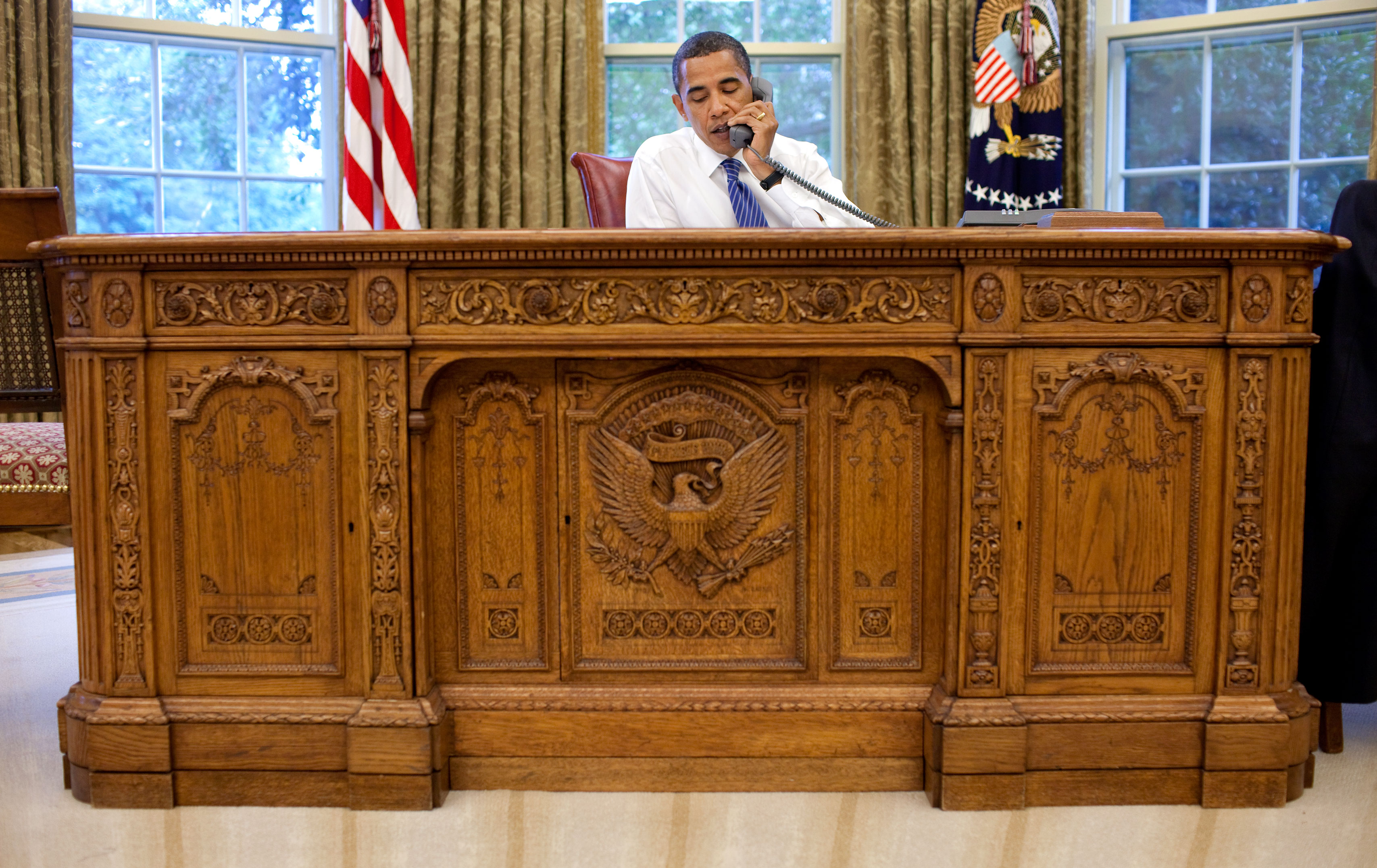 English: President Barack Obama sits behind th...