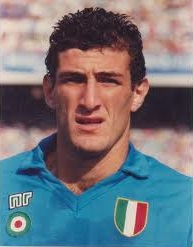 Photographie d'un joueur de football aux cheveux courts, bruns, avec un maillot bleu ciel, vu en gros plan.