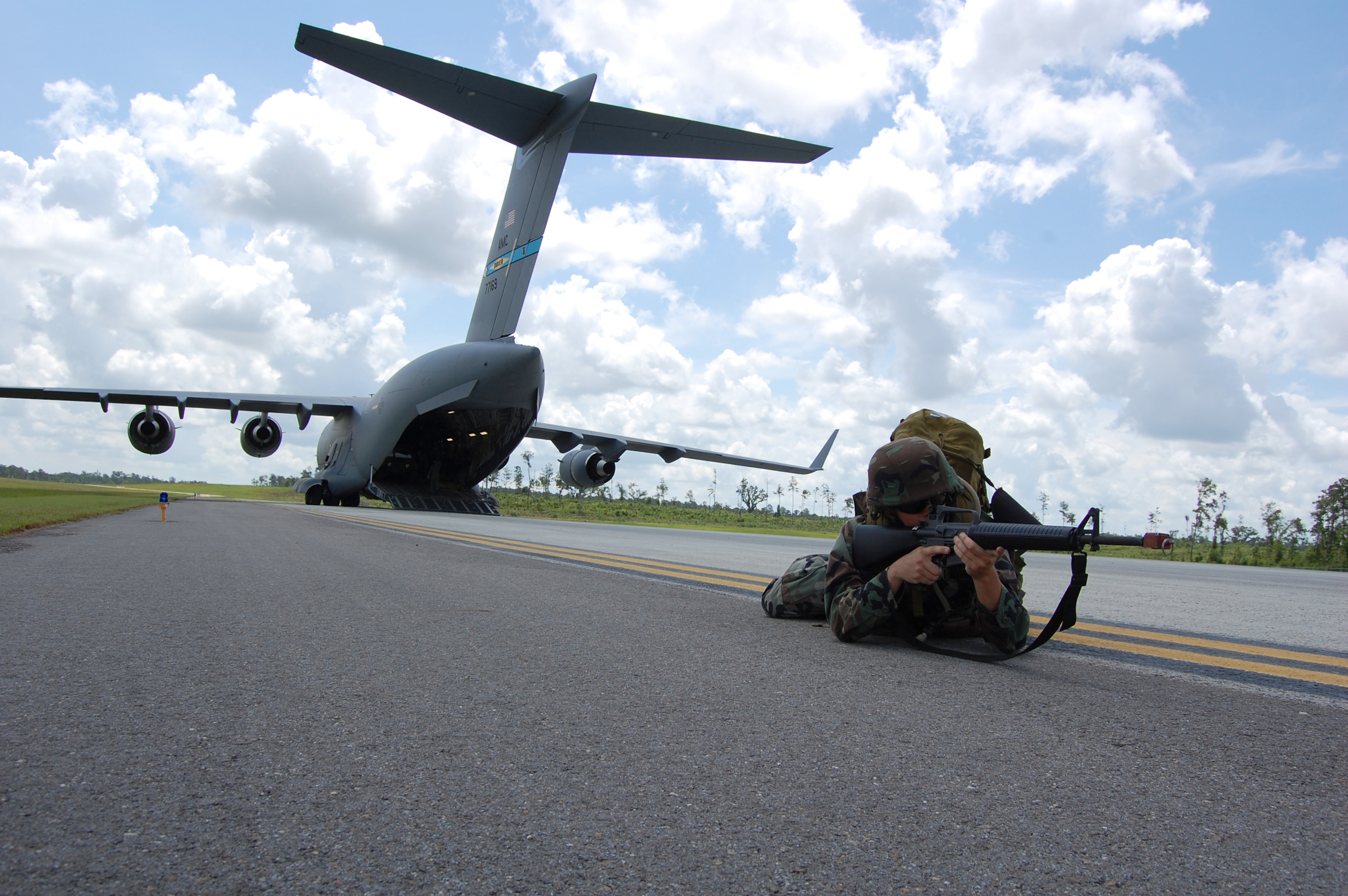 US Navy 080614-N-1057H-195 Sailors assigned to Naval Mobile Construction Battalion (NMCB) 11 set up a secure 360-degree perimeter around the U.S. Air Force C-17 aircraft.jpg