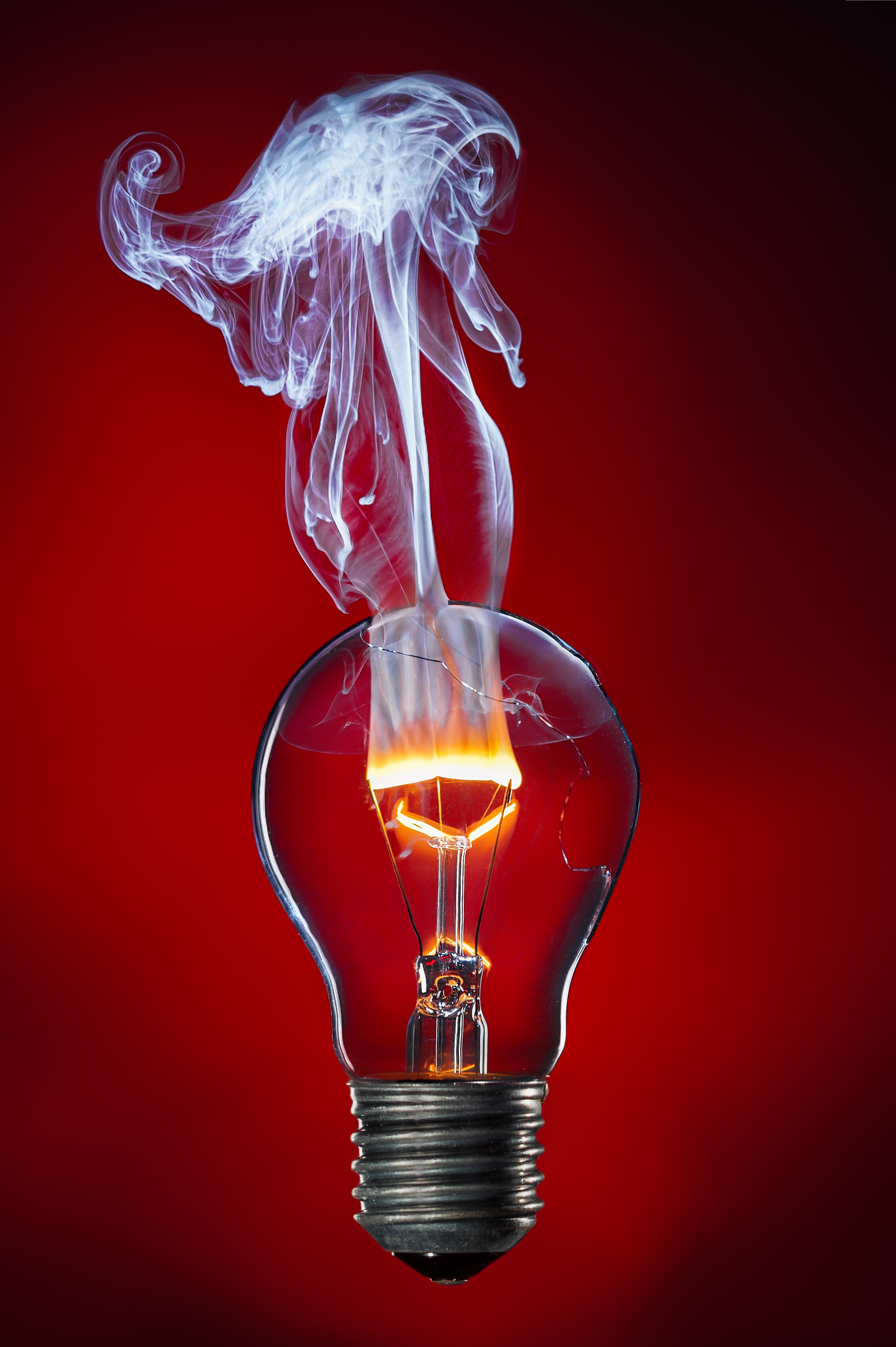 The tungsten filament burning with a flame in the light bulb.