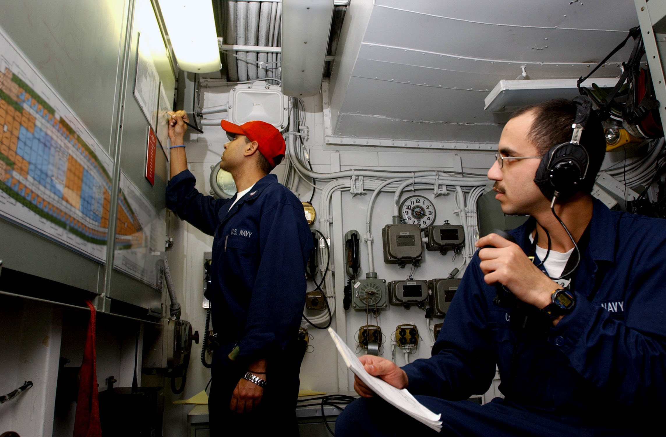 US Navy 030407-N-4953E-099 Fireman William Castro performs duties as Repair Locker Phone talker, reporting casualty information to Damage Controlman 3rd Class Omar Ortega, during a simulated fire drill aboard USS Harry S. Truma.jpg