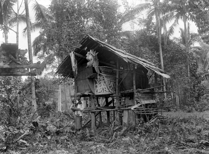 COLLECTIE TROPENMUSEUM Een dorpshoofd in Koetai met kind voor het graf van zijn vader TMnr 10017057