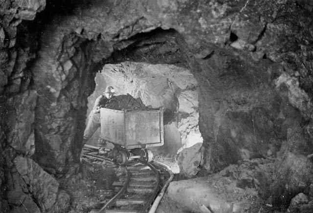 FileA miner hauling a car of silver radium ore 340 feet below the