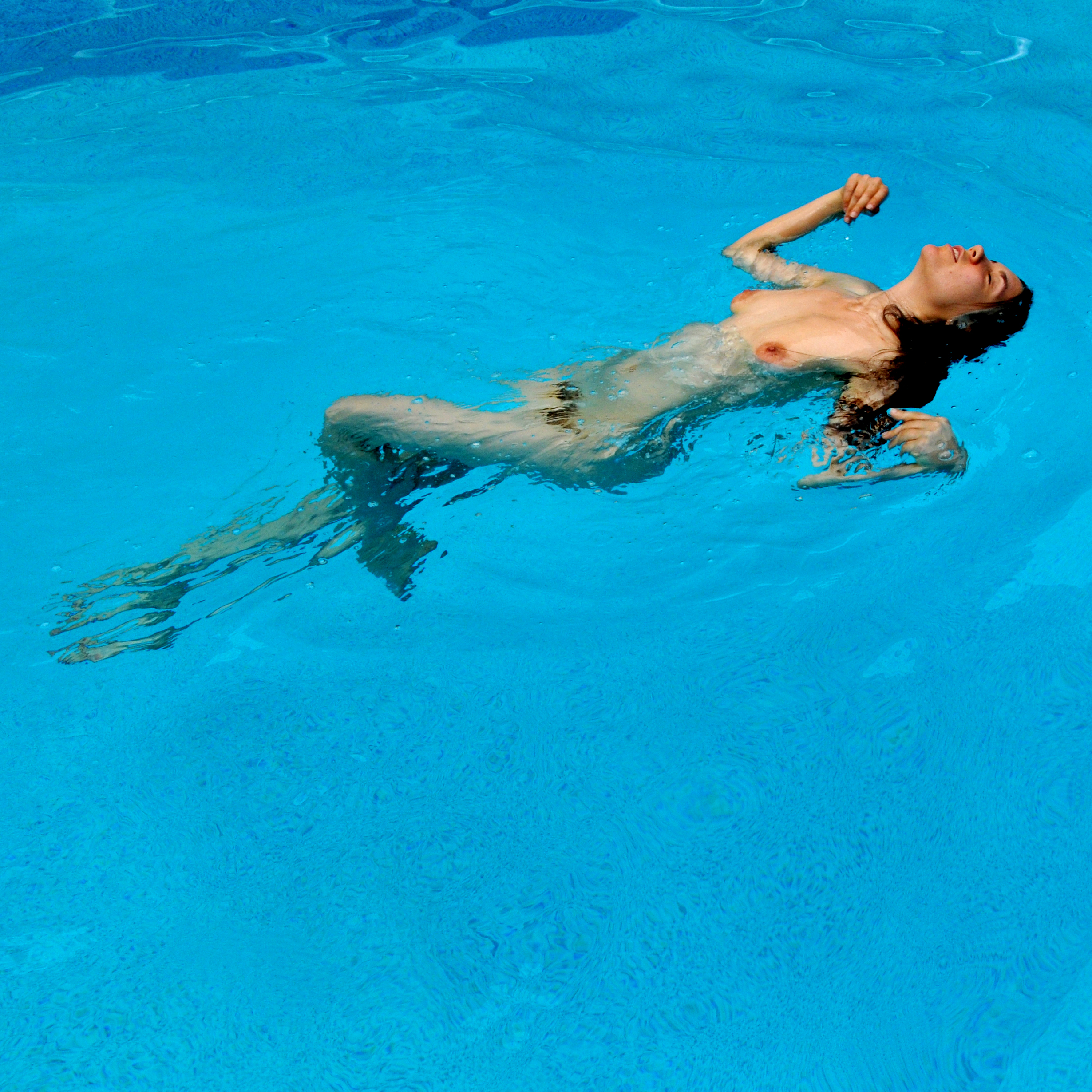 Nude girl in pool of mud