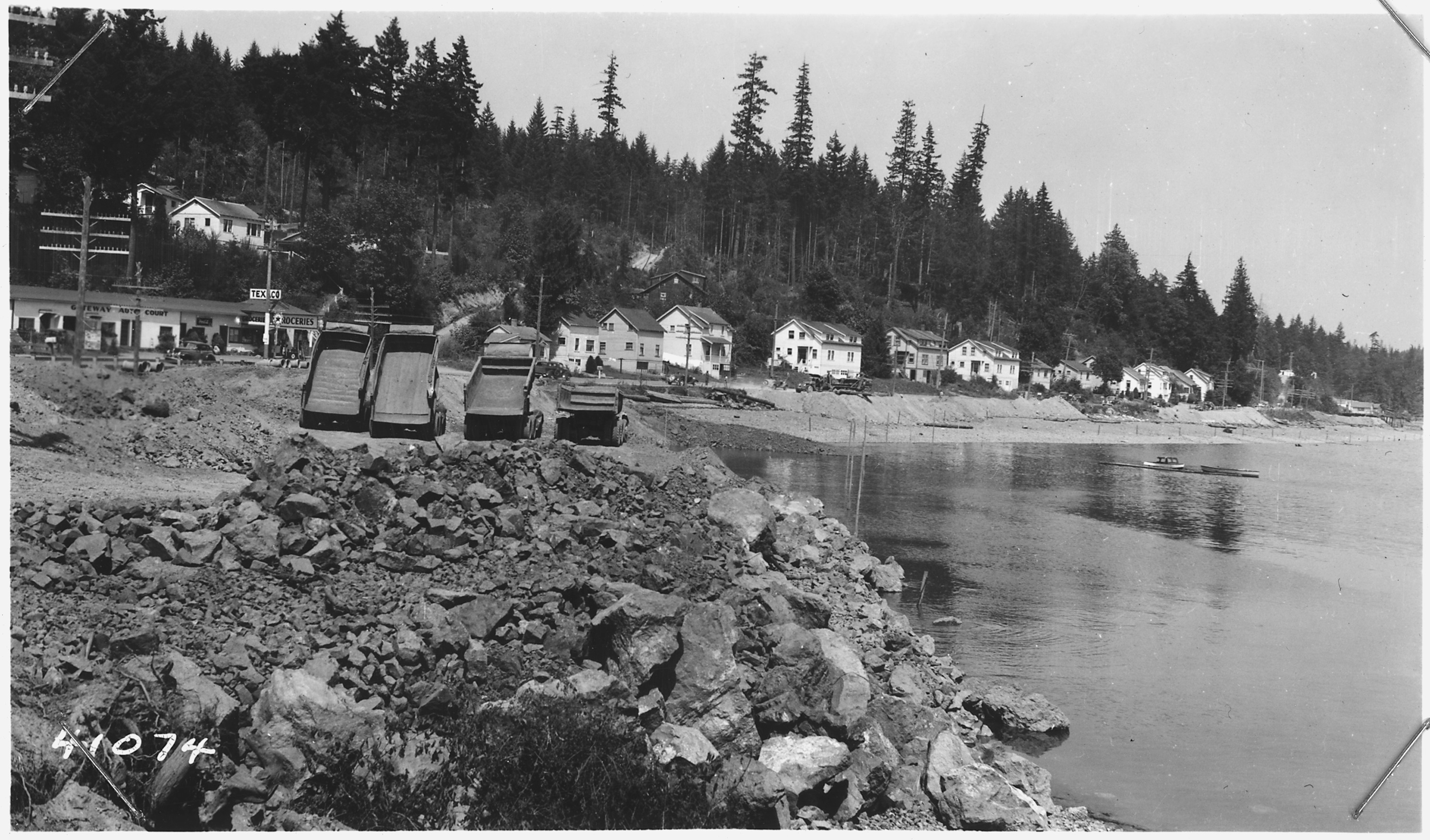 View_shows_in_foreground_rock_fill_slope_protection_at_about_Sta.75._Line_of_high_stakes_at_toe_of_fill_slope_low..._-_NARA_-_298221.jpg