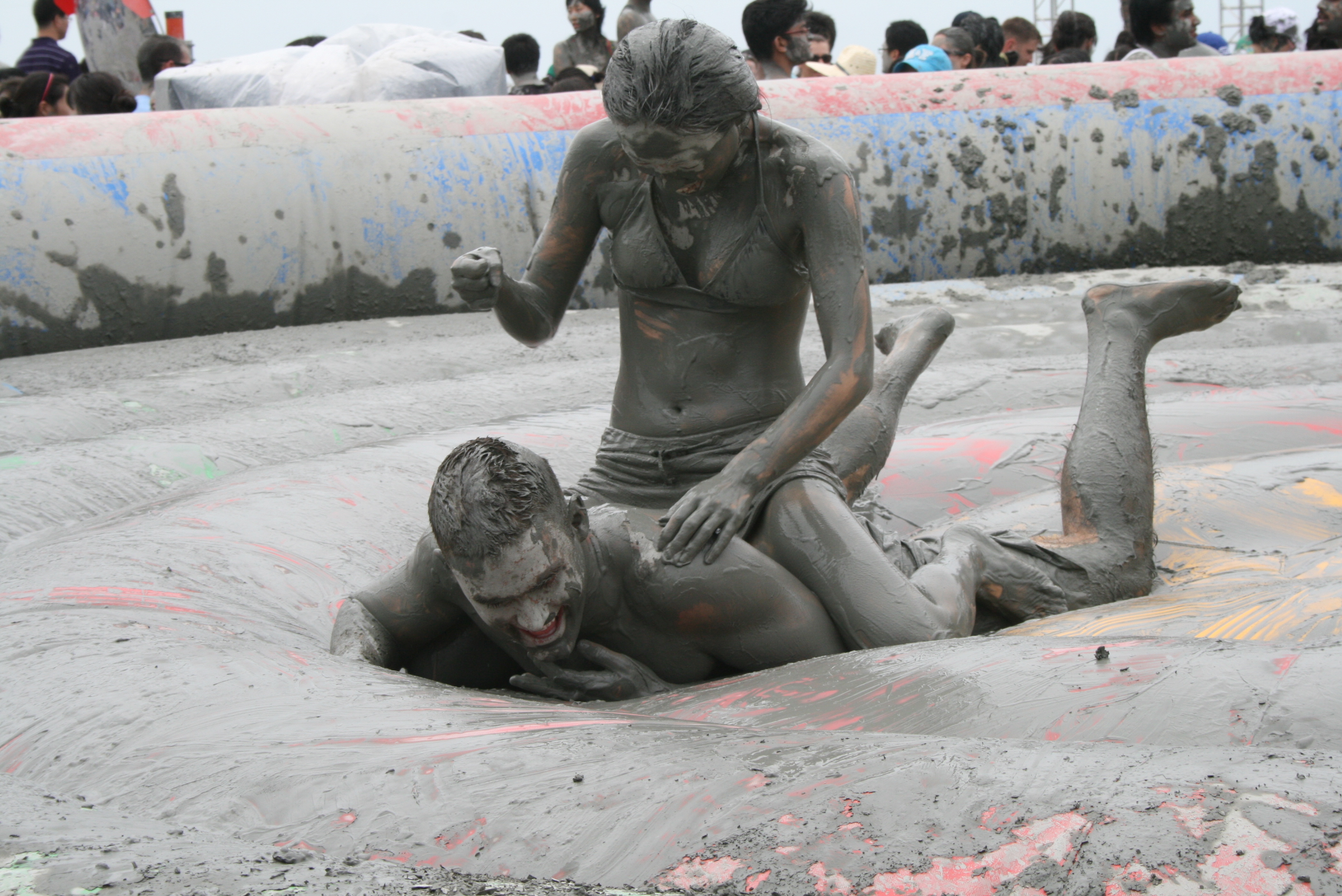 Nude girl in pool of mud