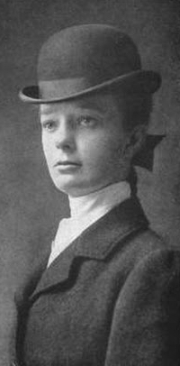 A young white woman in riding gear.