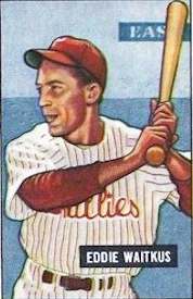 A baseball card image of a smiling man wearing a white baseball jersey striped with red and a red baseball cap holding a baseball bat over his shoulder