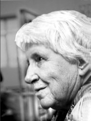 An older woman with olive skin and short white hair, photographed in profile