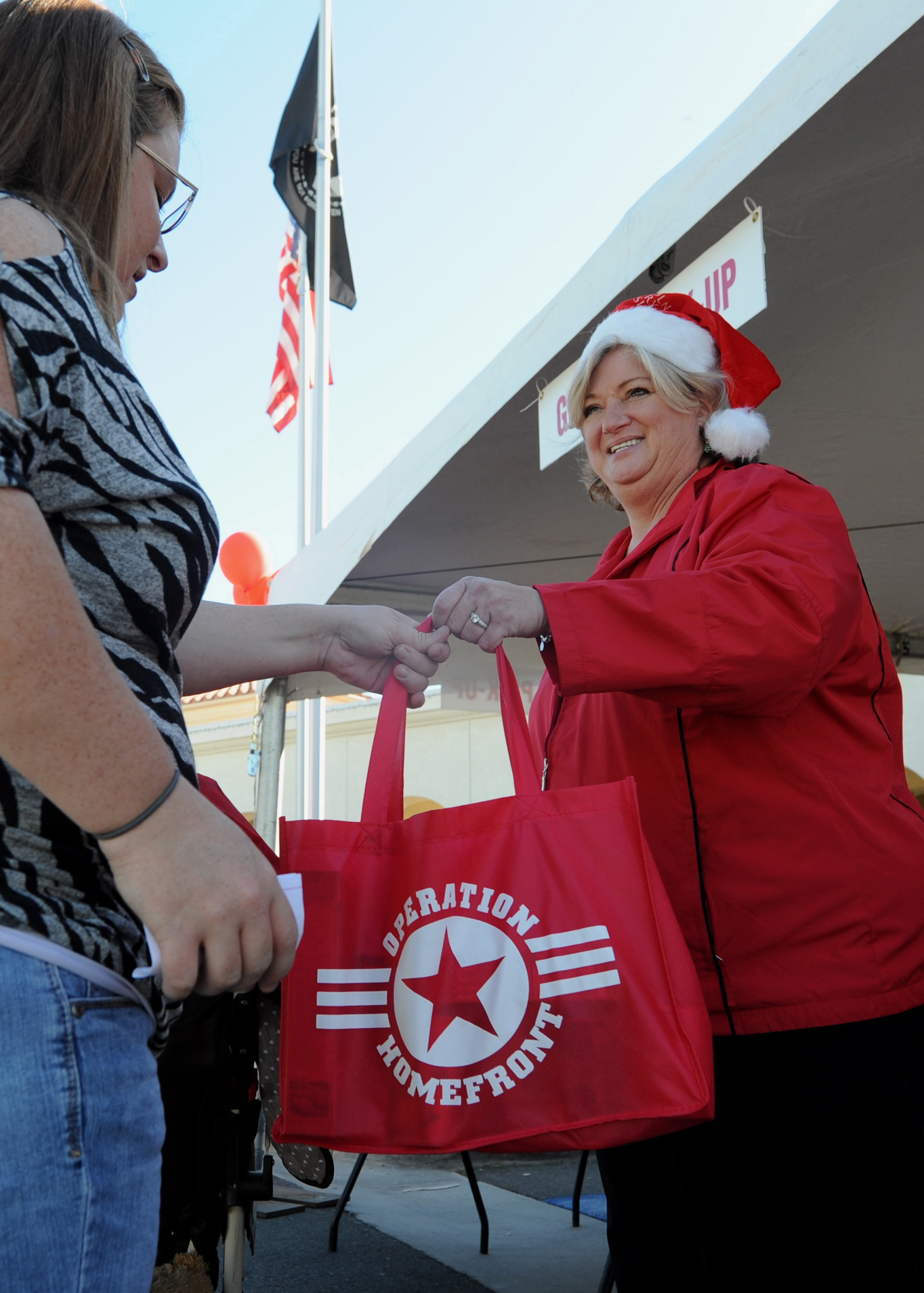 US Navy 111210-N-GI540-125 Dana Zini, the regional property manager of Lincoln Military Housing, passes out bags of non-perishable food items durin.jpg