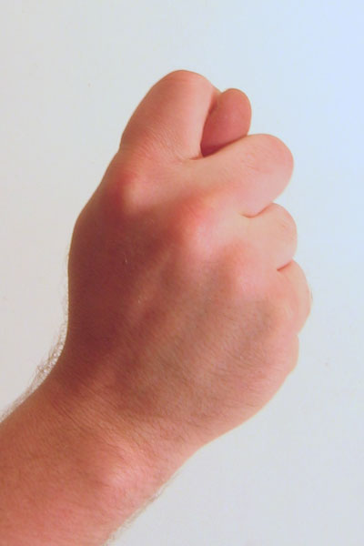 Ficheiro:Gesture fist with thumb through fingers.jpg