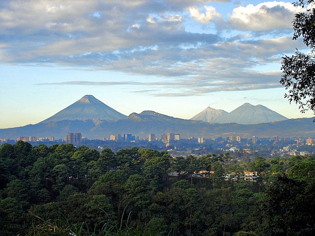 View of Guatemala City with the "Agua", "Fuego", "Acatenango" volcanoes in the background.