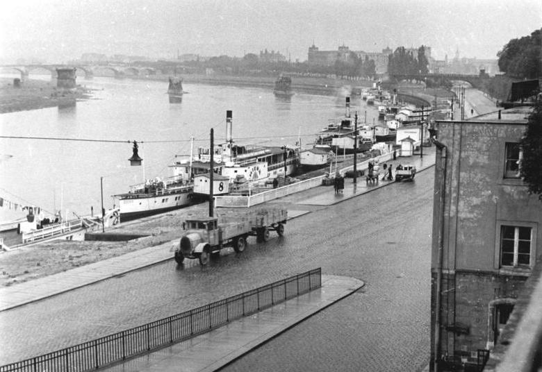 Terrassenufer mit dem Bereich der ehemaligen Elbfurt (in Höhe des Häuschens der "Weißen Flotte") und der ehemaligen sorbischen Holzbrücke (dahinter). Im Hintergrund die Strompfeiler der 1945 zerstörten Carolabrücke. Zustand 1952.