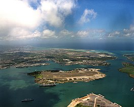 In loftfoto fan it Marinestasjon Pearl Harbor, mei yn 'e midden Ford Island.