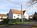 Wohnhaus, zwei aneinander gebaute Seitengebäude, Scheune, Toreinfahrt (mit Pforte) und Einfriedung mit Vorgarten eines Bauernhofes