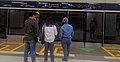 Passengers waiting near the platform screen door