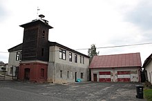 Hasičská zbrojnice s dřevěnou věží vybudovanou vlevo.