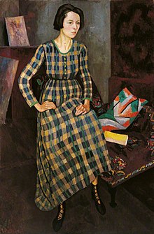 Nina Hamnett painted by Roger Fry, 1917, in a dress designed by Vanessa Bell and made at the Omega Workshops. The shoes may also be from Omega and the cushion on the chair is covered with 'Maud' linen, also by Bell. Nina Hamnett.jpg