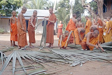Moines novices fabriquant des supports de manuscrits en feuilles de palme. Laos