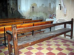 Detalle de bancos de madera y piso de ladrillos hidráulicos en la iglesia parroquial de Arroyo Cerezo, Castielfabib (Valencia).