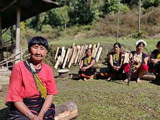 An elderly Adi women leading a folk song