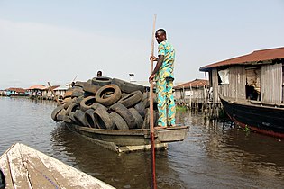 Marchand de pneus en pirogue dans la cité lacustre de Ganvié au Bénin en 2017.