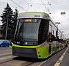 A green and gray tram