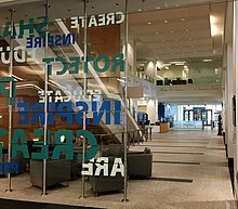 The lobby of the Public Search Facility, looking out toward the atrium, inside the Madison Building of the USPTO. The bronze bust of Thomas Jefferson is at the far right. Researchers can access patent search databases within the facility. PSF at USPTO Madison Bldg.jpg