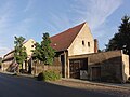 Wohnhaus mit Toreinfahrt und seitlichem eingeschossigen Ladenanbau