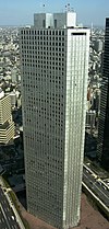 Aerial view of a gray, triangular, window-dotted high-rise