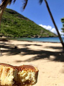 Photo d’une plage avec au premier plan un gâteau.