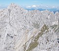 Übergang vom Treffauer zur Ellmauer Halt (hinten links), dazwischen der grasige und schrofige Westrücken des Kaiserkopfes, dahinter die Rote-Rinn-Scharte