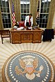 Barack Obama dans le bureau ovale en janvier 2009, quelques jours après son investiture. Le sceau est visible sur le tapis (créé sous l'administration Bush), gravé dans le bois du panneau central du Resolute desk, le bureau utilisé par la plupart des présidents américains et sur le drapeau présidentiel, à gauche derrière le bureau.
