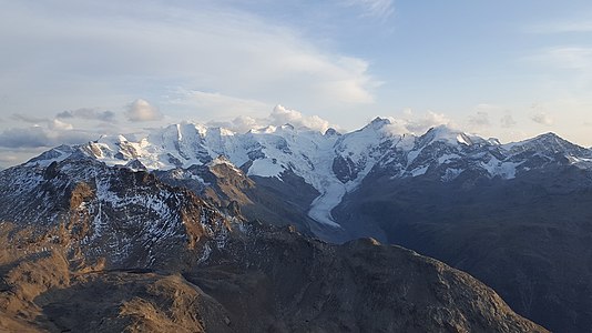 Blick nach Süden zur Berninagruppe mit (v. l. n. r.) Piz Caral, Piz d’Arlas, Piz Cambrena, Piz Palü, Piz Spinas, Bellavista, Piz Zupò, Piz Argient, Crast’ Agüzza, Piz Bernina, Piz Prievlus, Piz Morteratsch, Piz Boval und Piz Tschierva. Vor dem Gebirgszug der Morteratschgletscher, ganz vorne links der Piz Albris