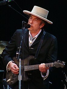 Bob Dylan playing an electric guitar.