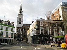 Église centrale, enserrée de bâtiments s'ouvrant en V.