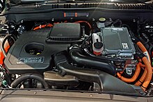 Hybrid 2.0L gasoline powered-engine (left) and inverter system controller on top of the AC electric motor. Ford Fusion Energi WAS 2017 1637.jpg