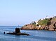 The HMSC Corner Brook submarine travelling past the remains of the coastal defences